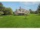 Expansive backyard with lush green lawn and view of the home's rear elevation and deck at 5661 Rutland Trce, Lithonia, GA 30058