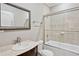 Bathroom featuring bathtub/shower combo with glass doors, toilet, sink, and decorative mirror at 5661 Rutland Trce, Lithonia, GA 30058