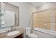 Bathroom features shower/bathtub combo with glass doors, toilet, decorative mirror, and sink at 5661 Rutland Trce, Lithonia, GA 30058
