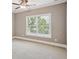 Bright bedroom features neutral carpet, a ceiling fan, and a window with blinds at 5661 Rutland Trce, Lithonia, GA 30058