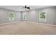 Bright bedroom with neutral carpet, three windows, and ceiling fan, bathed in natural light at 5661 Rutland Trce, Lithonia, GA 30058