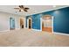 Spacious carpeted living room featuring a blue accent wall, archways, and doorways at 5661 Rutland Trce, Lithonia, GA 30058