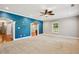 Living room with plush carpet, blue accent wall, and decorative archway leading to other rooms at 5661 Rutland Trce, Lithonia, GA 30058