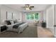 Primary bedroom with neutral walls, ceiling fan, and a large window with a wooded view at 1378 Sheffield Glen Ne Way, Atlanta, GA 30329