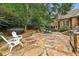 Spacious backyard with a flagstone patio, in-ground pool, fire pit, and outdoor grilling station surrounded by mature trees at 145 Ardsley Ln, Alpharetta, GA 30005