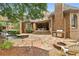 Brick home exterior showcasing a lush backyard with a stone patio, built-in grill, and a cozy fire pit seating area at 145 Ardsley Ln, Alpharetta, GA 30005