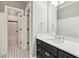 Bathroom boasts sleek black cabinetry, a white countertop, and elegant fixtures complementing the black and white tiled flooring at 145 Ardsley Ln, Alpharetta, GA 30005