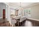 Dining room with a crystal chandelier, plantation shutters, and hardwood floors at 145 Ardsley Ln, Alpharetta, GA 30005