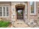 Elegant double front doors framed by stone archway and brick accents at 145 Ardsley Ln, Alpharetta, GA 30005