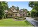 Charming front exterior with stone and wood accents, lush green lawn and manicured landscaping at 145 Ardsley Ln, Alpharetta, GA 30005