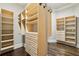 Walk-in closet features hardwood floors and custom built-in shelving and drawers at 145 Ardsley Ln, Alpharetta, GA 30005