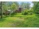 View of the grassy backyard with mature trees and a screened in porch at 3120 Beechwood Se Dr, Marietta, GA 30067