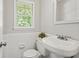 Small bathroom with tile wainscot, white toilet and sink at 3120 Beechwood Se Dr, Marietta, GA 30067