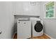 Bright laundry room with white washer and dryer, cabinets, and a window for natural light at 3120 Beechwood Se Dr, Marietta, GA 30067