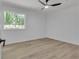 Bright bedroom with hardwood floors, ceiling fan, and a window showcasing the lush greenery outside at 373 Hemlock Dr, Lawrenceville, GA 30046