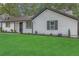 Charming single-story home with a lush green lawn, white siding, black trim, and neatly manicured landscaping at 373 Hemlock Dr, Lawrenceville, GA 30046