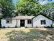 Charming home featuring a bright white exterior, black trim, complemented by a well-manicured front yard with lush landscaping at 373 Hemlock Dr, Lawrenceville, GA 30046