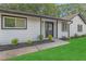 Inviting home entrance with a black front door, white siding, well-kept lawn, and manicured landscaping at 373 Hemlock Dr, Lawrenceville, GA 30046