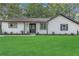 Charming single-story home with a lush green lawn, white siding, black trim, and neatly manicured landscaping at 373 Hemlock Dr, Lawrenceville, GA 30046