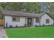 Charming single-story home with a lush green lawn, white siding, black trim, and neatly manicured landscaping at 373 Hemlock Dr, Lawrenceville, GA 30046