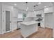 Modern kitchen featuring white cabinets, a large island, and stainless steel appliances, offering a contemporary design at 373 Hemlock Dr, Lawrenceville, GA 30046