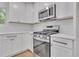 Close-up view of kitchen featuring stainless steel appliances, white cabinets, and elegant countertops at 373 Hemlock Dr, Lawrenceville, GA 30046