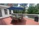 Outdoor deck with a glass-top table, chairs, and an umbrella, overlooking a serene wooded area and pond at 1813 Baldwin Farms Dr, Marietta, GA 30068