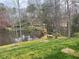 Scenic backyard with a pond, trampoline, and cozy seating area around a fire pit, perfect for outdoor enjoyment at 1813 Baldwin Farms Dr, Marietta, GA 30068