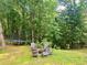 Backyard featuring a trampoline and a charming seating area with a fire pit surrounded by lush trees at 1813 Baldwin Farms Dr, Marietta, GA 30068