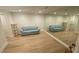 Finished basement with light wood floors, a large mirror, and a comfortable blue sofa at 1813 Baldwin Farms Dr, Marietta, GA 30068