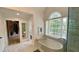 This bathroom features a soaking tub next to a glass shower, as well as access to a large walk-in closet at 1813 Baldwin Farms Dr, Marietta, GA 30068