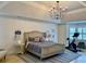Spacious bedroom features neutral decor, tray ceilings, a modern light fixture, and workout space at 1813 Baldwin Farms Dr, Marietta, GA 30068