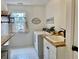 Bright laundry room features new washer and dryer, folding table, and decor at 1813 Baldwin Farms Dr, Marietta, GA 30068