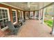 Covered brick patio with ceiling fans and white pillars, adorned with decorative benches and chairs at 1813 Baldwin Farms Dr, Marietta, GA 30068