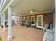 Covered brick patio with white pillars, two ceiling fans and outdoor seating; accessible from double doors at 1813 Baldwin Farms Dr, Marietta, GA 30068