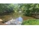 Picturesque pond view with a fountain, dock, and seating, surrounded by lush greenery at 1813 Baldwin Farms Dr, Marietta, GA 30068