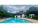 Bright and inviting community pool surrounded by lush greenery, lounge chairs, and a pergola at 1813 Baldwin Farms Dr, Marietta, GA 30068