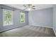 This bedroom features two windows, neutral carpet and cool light-blue painted walls at 2316 Fripp Overlook Nw, Acworth, GA 30101