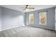 Light-blue painted bedroom featuring two windows, neutral carpet, and ceiling fan at 2316 Fripp Overlook Nw, Acworth, GA 30101