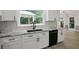 Bright kitchen showcasing white cabinets, black appliances, granite countertops, and a view of the outdoor patio at 2316 Fripp Overlook Nw, Acworth, GA 30101