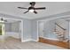 Open living space with hardwood floors, light-colored walls, staircase, and view into the kitchen at 2316 Fripp Overlook Nw, Acworth, GA 30101