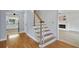 Staircase with hardwood floors, freshly painted white walls, and an adjacent living space at 2316 Fripp Overlook Nw, Acworth, GA 30101