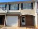 Charming two-story townhouse with a one-car garage and a brick-accented front porch entry at 730 Georgetown Ln, Jonesboro, GA 30236