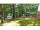 Expansive backyard with mature trees, green lawn and a peek at the house down the street at 2179 Mountclaire Ct, Stone Mountain, GA 30087