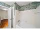 Bathroom featuring a white tub and shower, and patterned wall paper at 2179 Mountclaire Ct, Stone Mountain, GA 30087