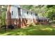 Exterior featuring red brick and white home, green grass, and plenty of foliage at 2179 Mountclaire Ct, Stone Mountain, GA 30087