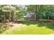 Lush lawn surrounds the exterior of a home with a charming brick facade nestled among the trees at 2179 Mountclaire Ct, Stone Mountain, GA 30087