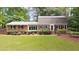 Charming single-story brick home featuring a well-manicured lawn and lush landscaping at 2179 Mountclaire Ct, Stone Mountain, GA 30087
