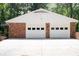 Two-car garage featuring white doors with square windows and red brick construction at 2179 Mountclaire Ct, Stone Mountain, GA 30087