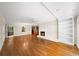 Spacious living area with hardwood floors, white brick fireplace, large windows, and a ceiling fan at 2179 Mountclaire Ct, Stone Mountain, GA 30087